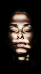 Fototapeta premium Female adult with dramatic light patterns on face in darkness