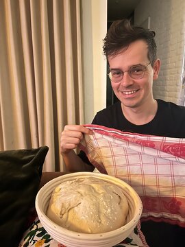 smiling baker holding dough in cozy home environment