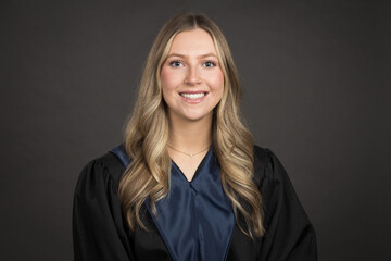 portrait of a young woman in a graduation gown smiling