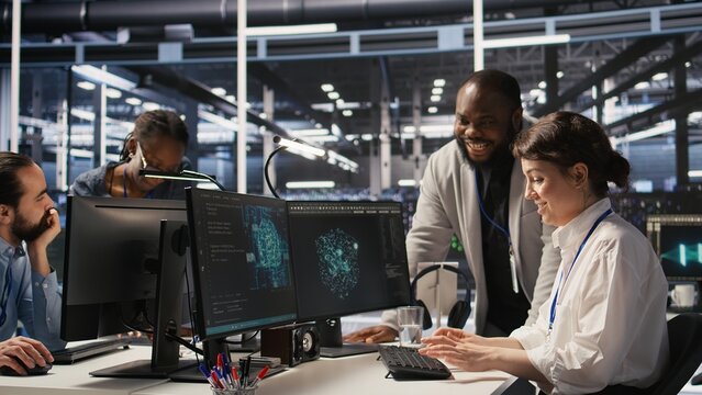 Joyous data center team leader giving high five to worker after successful infrastructure upgrade. Pleased coworkers celebrating collaborative achievement during AI systems deployment, camera A