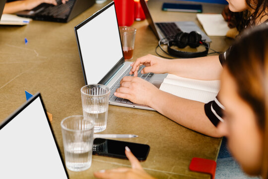 Unknown office worker typing on a laptop inside a collaborative cowork