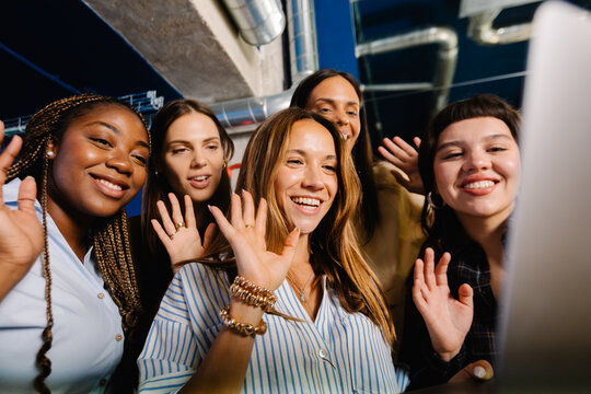 Female entrepreneurs attend a virtual conference via laptop