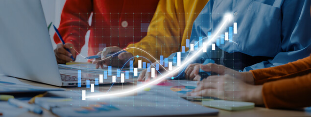 A diverse business team collaborates at a desk, analyzing growth trends with a laptop and graphs, emphasizing data visualization and strategic planning. Axiom