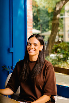 Businesswoman posing cheerfully in a boardroom at a coworking facility