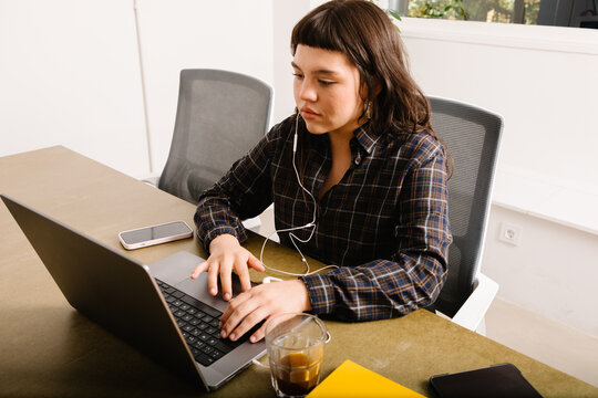 A female professional using a laptop at her desk 