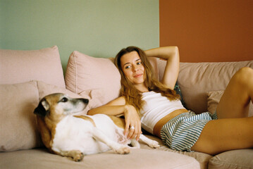 Woman Relaxing on Sofa with Her Dog at Home
