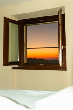 Sunrise view through open bedroom window