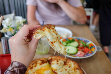 Holding cheesy bread at lunch