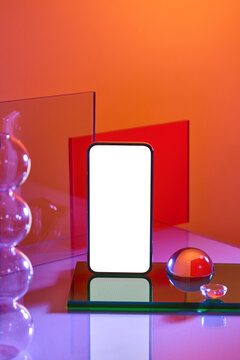 A sleek smartphone with a blank screen displayed on geometric shapes