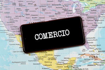 an a smart phone with a white comercio word in spanish or commerce word in english over a north...