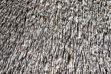 Close-up of structure an old straw thatched roof under bright sunlight