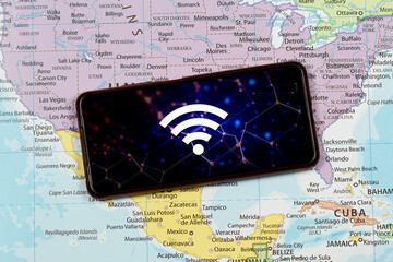 close up to an a smart phone with a composition image of wifi symbol over a north american political map