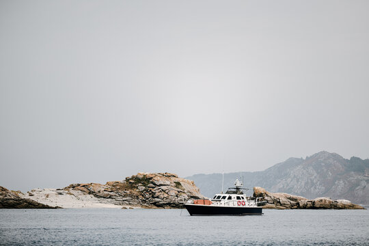 Boat near rocky coastline of cies islands in galicia spain