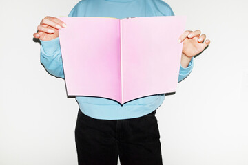 Person holding reading pink mockup paper magazine with space for text