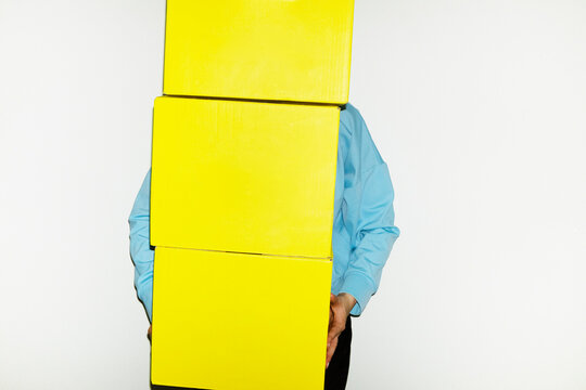 Person holding yellow mockup delivery package box with space for text