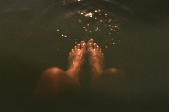 Woman's wet feet dip in lake water
