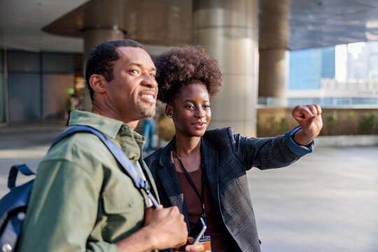 Two people looking and pointing at something in the distance.