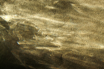 natural light reflection background on a rough textured golden brown surface