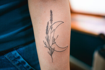 Fresh crescent moon and lavender tattoo on arm