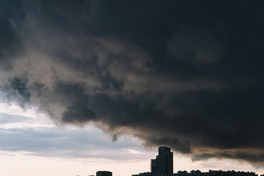 Dark clouds loom over urban skyline during sunset