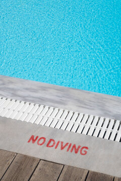 Turquoise swimming pool edge and no diving sign