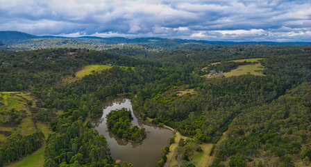 Obraz premium Forested dam surrounded by rolling Upwey bushland