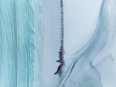 Gentle waves and sand patterns on a beach at blue hour