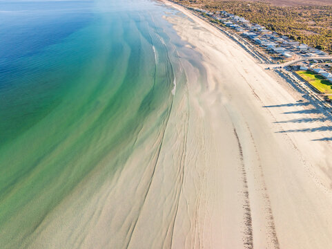 Gentle waves and ripples of water on a white sandy beach