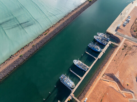 Boats moored at a jetty in a coastal marina channel