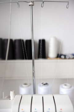  A close-up view of a a serger, with several spools of thread.