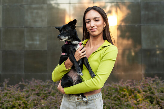 Stylish female embraces dog for responsible pet care