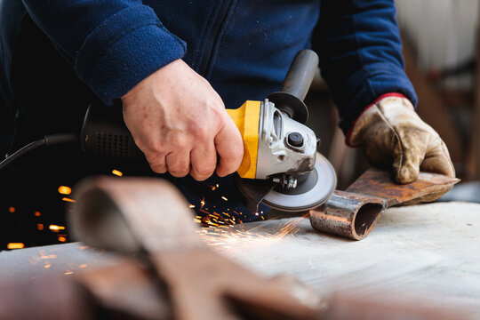 Close-up of Worker Grinding Metal with Power Tool