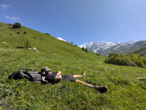 Guy resting on slope of a mountain during a hike