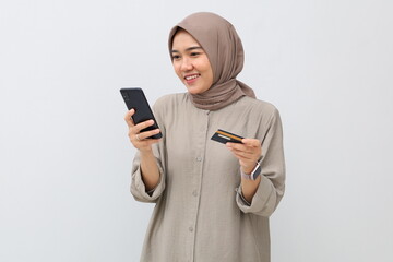 Young Asian muslim Woman holding credit card and using smartphone , shopping online, e-commerce, internet banking, spending money