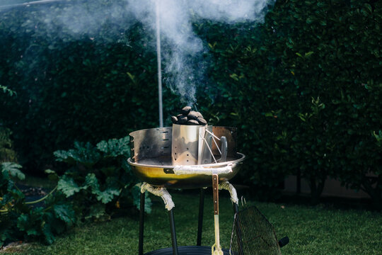 Outdoor smoker emitting smoke in backyard
