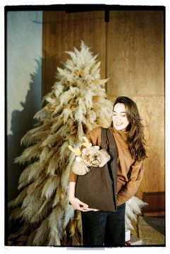 Happy woman with cute brown poodle dog near the Christmas tree 