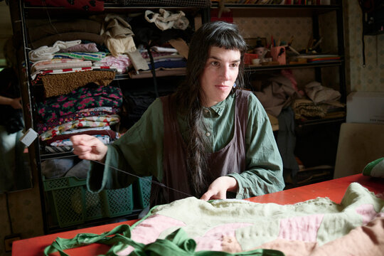 Skillful artisan stitching a patchwork quilt in a cozy workshop