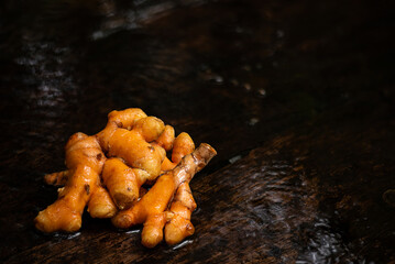Turmeric or Curcuma longa rhizome on an old wooden background.