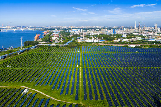 Aerial view of solar panel field with chemical industrial park