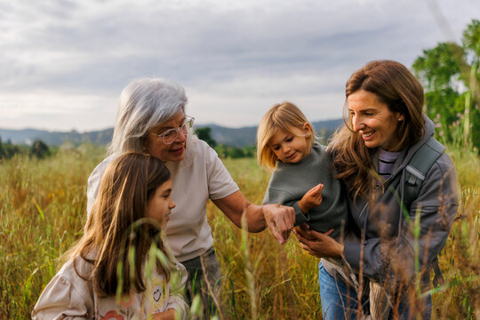 Three generations exploring nature together in a meadow