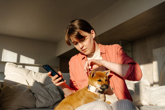 Woman checking GPS tracker on puppy collar