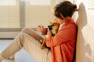 Puppy receiving oral medicine from owner with dropper indoors