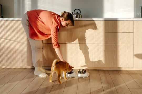 Woman stroking dog while eating