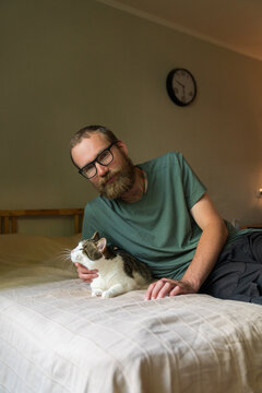 Man Relaxing on Bed with One-Eyed Cat