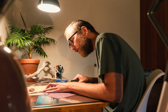 Man Focused on Craft Project at Home Desk