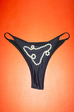 Black underwear panties with shiny pearl jewellery necklace 