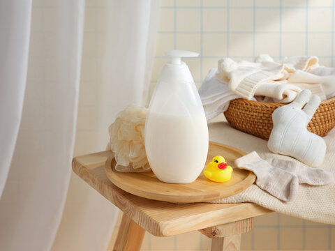 A calming bathroom scene featuring lotion, a duck, and soft towels