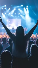 Enthusiastic concert attendee with arms raised in celebration silhouetted against a vibrant stage with bright spotlights and a cheering crowd