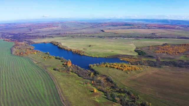 An aerial shot captures the serene landscape of Lake Alashskoye, located near Shihan Juraktau in the South Ural region of Russia. The footage shows the deep blue water of the lake surrounded by a patc