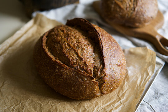 Crusty artisan sourdough bread on parchment
